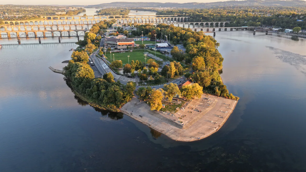 City Island surrounded by calm water, with autumn trees and bridges in the distance