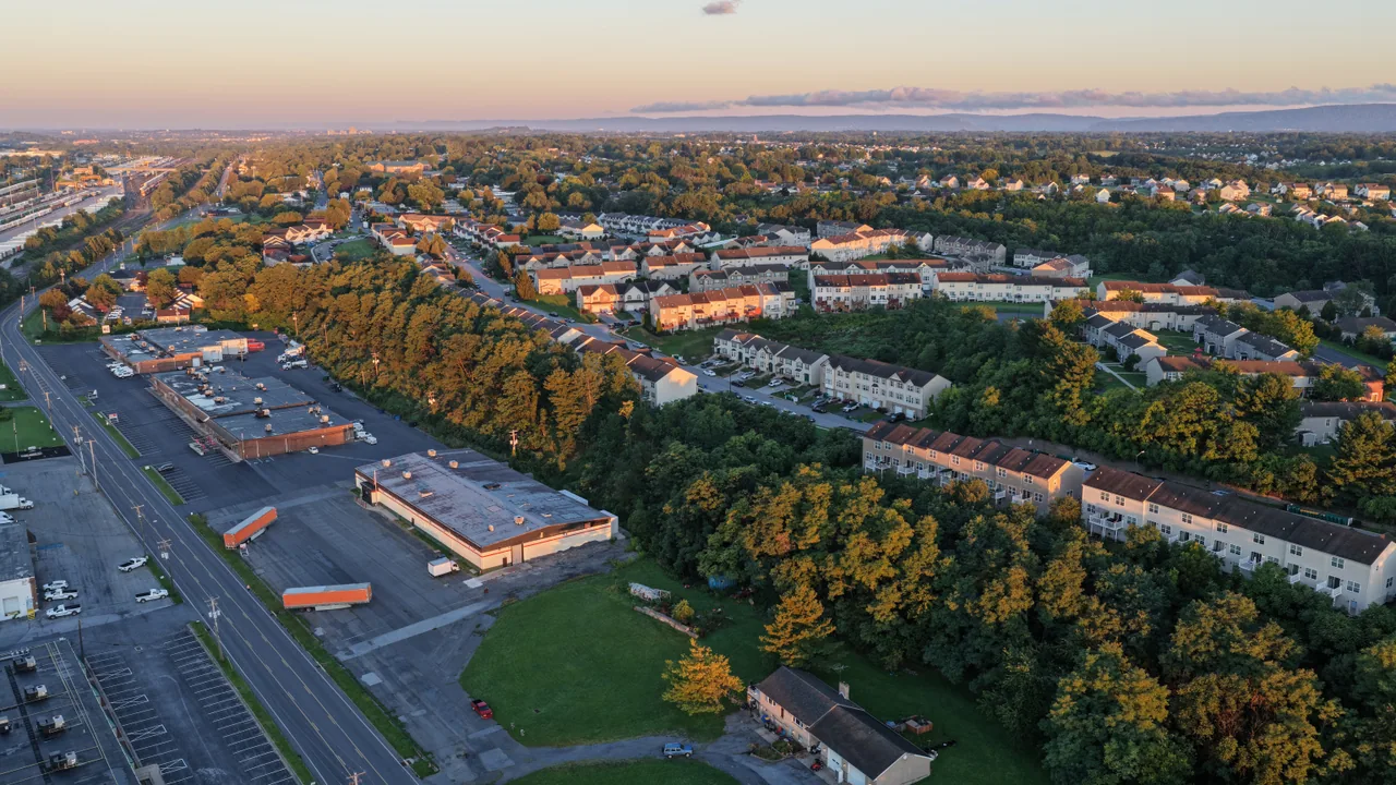 Neighborhood streets, buildings and trees seen from above in soft early morning light