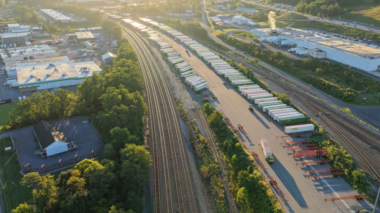 Rail tracks, loading yards and industrial buildings stretching into warm morning light